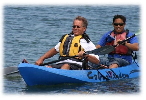 Men paddling kayak in teambuilding exercise