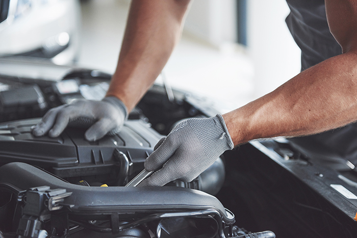 Automotive Technology stock photo of mechanic working on the engine of a car.